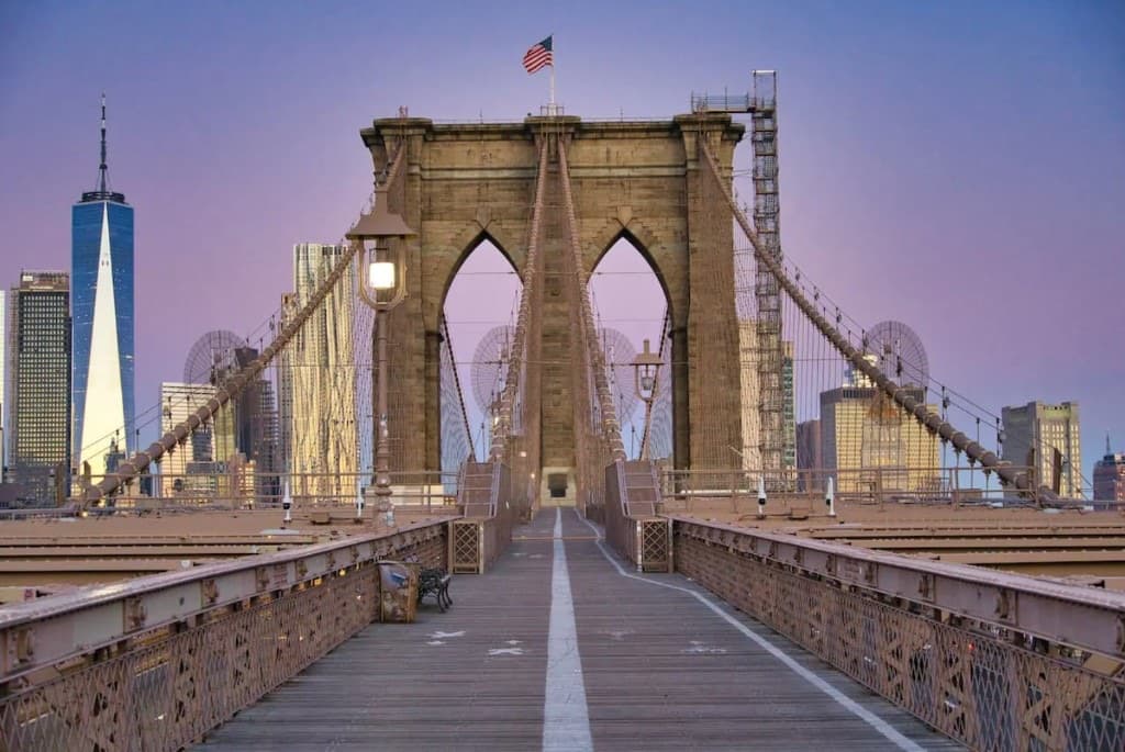 Pedestrian walkway on the Brooklyn Bridge at dusk looking toward Manhattan